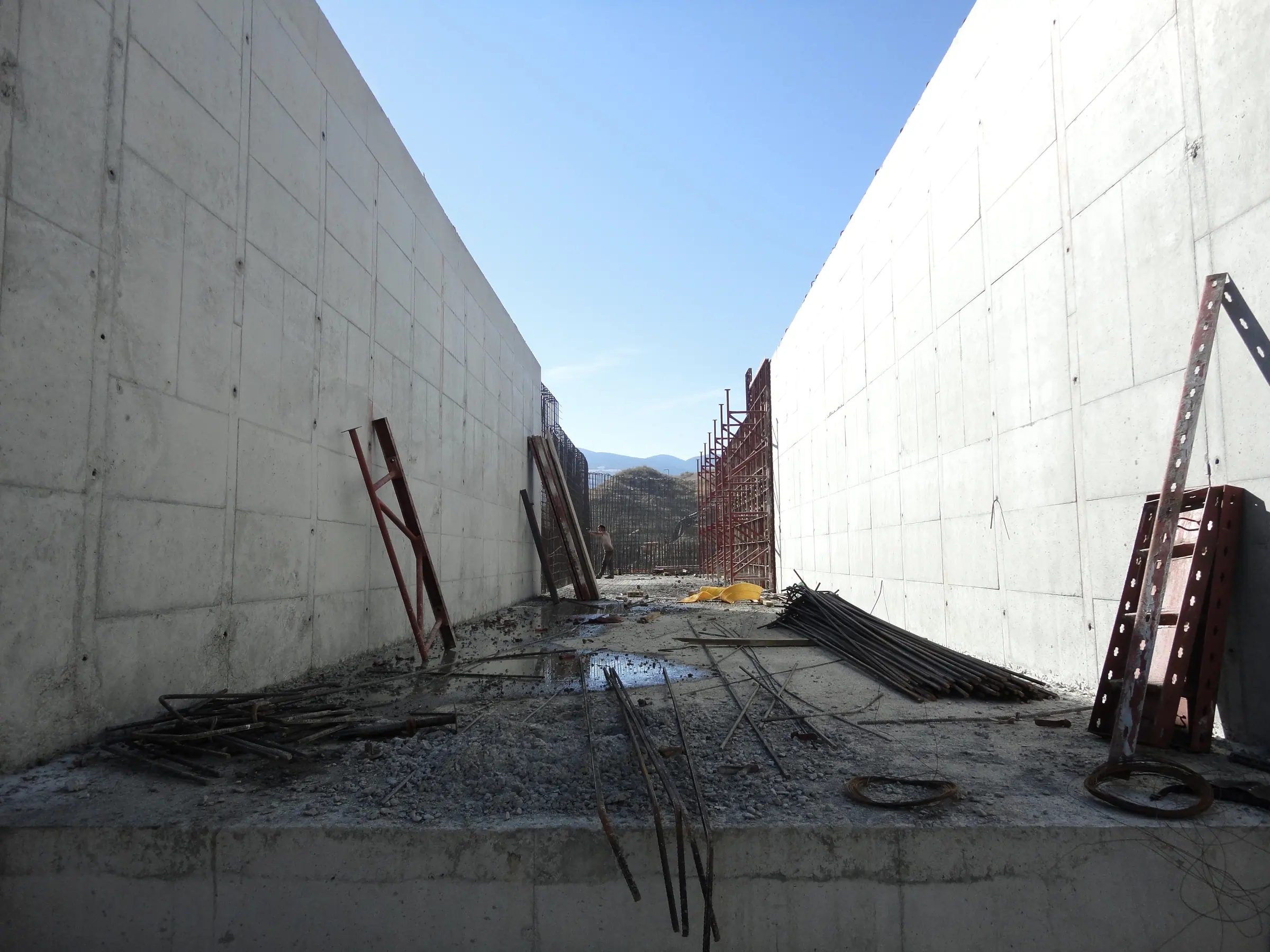 İki yüksek betonarme perde arasındaki derin kanal tabanında toplanmış donatı demetleri ve çelik payandalar
