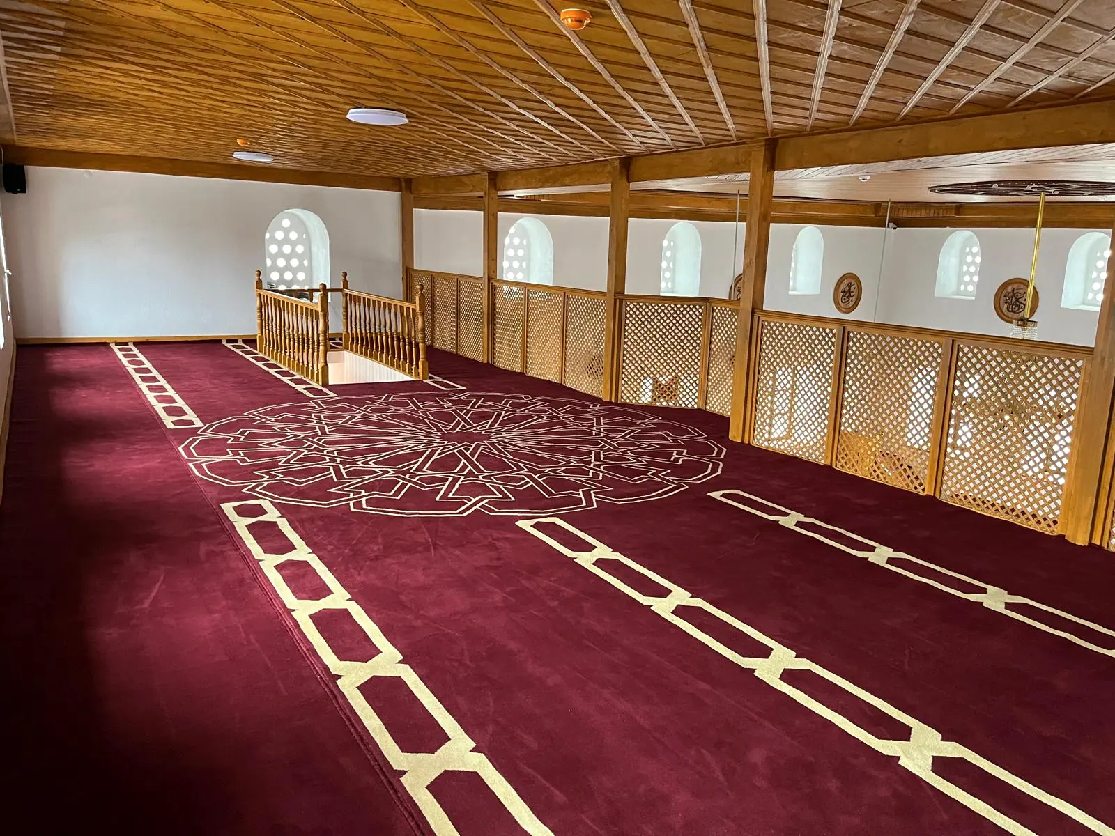 Üst kat mahfil: bordo göbekli cami halısı, kafes panelli ahşap korkuluk ve ahşap kaplama tavan